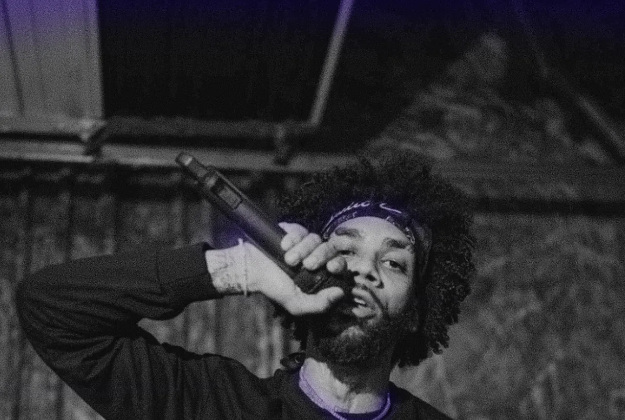 Prezident Cutt performing with a microphone raised